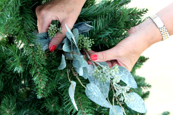Ladies hands arranging foliage on christmas tree