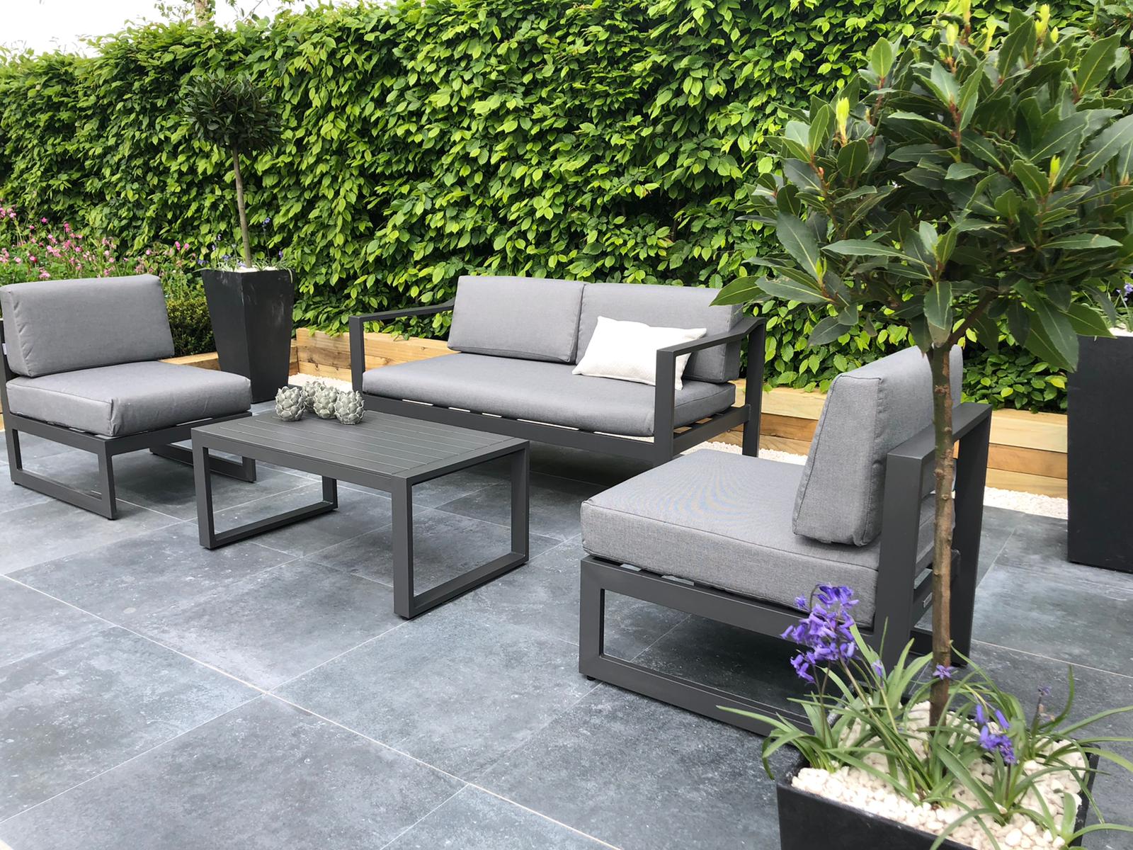 A four seater outdoor furniture lounge set in a contemporary garden design.